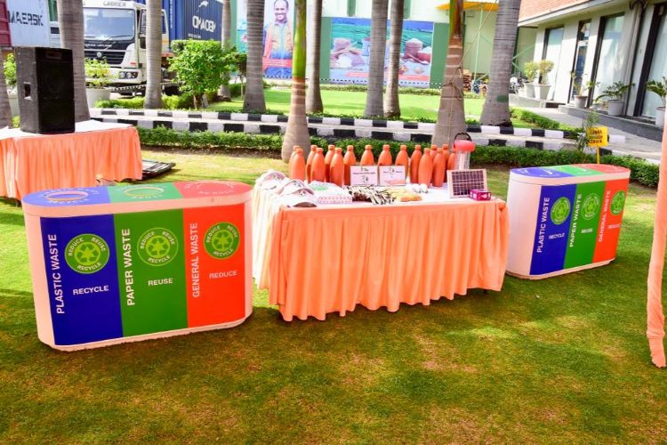 Display of waste segregation bins, earthen water bottles, recycled A4 paper sheets, solar lights and LEDs